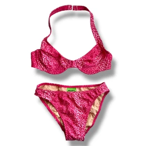 Rosa leopardmönstrad bikini från Pilpel - Snygg bikini från 2000-talet! Tyget är skimrande! Överdelen har bygel och halterneck-band. Står strl 8, passar mig perfekt som har strl 36. Använd gärna köp nu <3