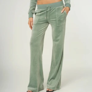 Gröna Juicy Couture byxor - Mysiga ljusgröna byxor från Juicy Couture med bred resårmidja och snörning. Byxorna har raka, vida ben och stora fickor fram och bak med knappdetaljer. Perfekta för en chill och trendig look.
