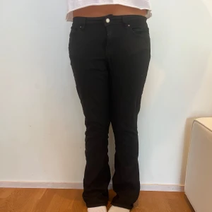 Svarta bootcut jeans med normal midja - Snygga svarta jeans som är bootcut. Modellen på bild är 171 cm lång. Lappen på byxorna är tyvärr bortklippt så vet ej vad de är för storlek men skulle gissa på 36-38. Byxorna är lite noppriga på låren efter användning men det går att ta bort med en noppermaskin eller liknande.