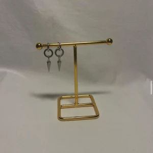 Silvriga örhängen med konformad detalj - Coola silvriga örhängen med små ringar och hängande konformade spikes. Perfekta för dig som gillar en edgy och modern stil. Passar både till streetwear och mer minimalistiska outfits.