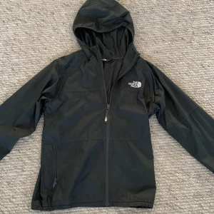 Svart vindjacka från The North Face - Säljer en svart riktigt schysst jacka från The North Face. Jackan är i mycket bra skick och är i storleken xs. Hör av er vid funderingar!