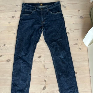 Mörkblå Lee Daren jeans - Snygga mörkblå Lee Daren jeans med klassisk rak passform och dragkedjegylf. Knappt använda och inga defekter. Nypris 1200. Pris kan diskuteras vid snabb affär.