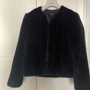 Svart pälsjacka från Stradivarius  - Säljer en svart pälsjacka från Stradivarius i storlek M. Jackan är fluffig och har en stilren, rak passform med långa ärmar. Perfekt för dig som vill ha en snygg och mysig look under kyliga dagar. Fodrad insida och stängs med diskreta hakar framtill.