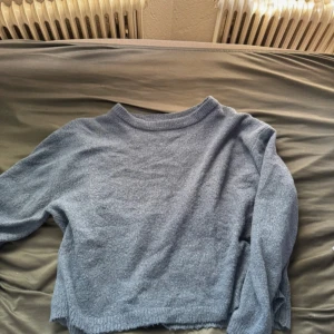 Ljusblå stickad tröja med rund hals - Mysig ljusblå stickad tröja med rund halsringning och långa ärmar. Från lager 157 i storlek M