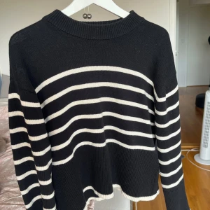 Randig svartvit stickad tröja Gina Tricot - Säljer en svart stickad tröja från Gina Tricot i storlek S. Tröjan har vita horisontella ränder, ribbad rund halsringning och slitsar i sidorna. Perfekt för dig som gillar en klassisk men chill look.