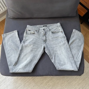 Grå jeans från Polo Ralph Lauren - Snygga grå jeans från Polo Ralph Lauren i klassisk femficksmodell. Jeansen har en rak passform och är tillverkade i mjukt denimtyg. Perfekta för dig som gillar en stilren och avslappnad look. Diskreta detaljer och logga på myntfickan. 