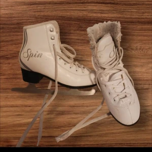 Vita skridskor Revolution Spin JR 34 - Snygga vita skridskor från Revolution, modell Spin JR, med fluffigt foder och klassisk snörning. Skridskorna har svart klack och silverfärgade detaljer. Perfekta för dig som vill åka stilrent på isen!