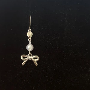 Söt örhänge med pärla och rosett - Handgjordt och unikt silverörhänge 🤩 Öronhängerna är nickelfria och silverpläterade i kirurgiskt stål, resterande av örhänget är i rostfritt stål (ej silverpläterat) 💕🙏3 cm långt. Alla köp görs via ”KÖP NU” knappen.  💐