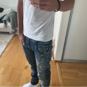 Blå Replay jeans med slitningar - Säljer ett par blå Replay jeans med snygga slitningar. De är hyperflex och modellen Anbass. Storlek 30L/30W. Hör av dig vid fler frågor eller annat!