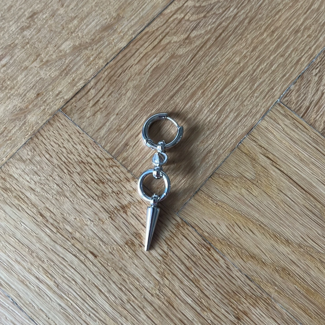 Silvrigt örhänge med spike-detalj