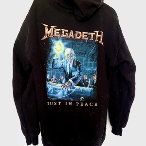 Megadeth hoodie Rust In Peace svart - Svart hoodie med Megadeth-tryck fram och stort Rust In Peace-albumomslag på ryggen. Dragkedja framtill, huva och fickor. Material i bra kvalitet. Passformen är lite baggy så den passar även större storlekar.