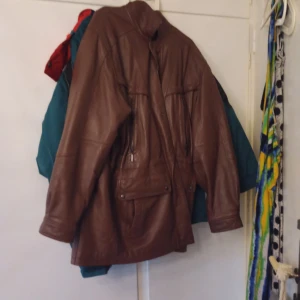 Brun skinnjacka med fickor - Säljer en brun skinnjacka med flera fickor och dragkedjedetaljer. Jackan har en klassisk passform och är tillverkad i mjukt skinn. Perfekt för dig som vill ha en tidlös och cool look.