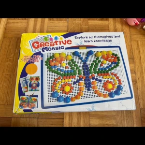 Creative Mosaic - Upptäck din kreativa sida med Creative Mosaic! Skapa färgglada mönster och figurer med hjälp av pärlor och mallar. Perfekt för dig som gillar pyssel, konst och att utmana din fantasi. Passar både unga och unga vuxna som vill ha kul och utveckla sin kreativitet.Bara kartongen är lite bruten annars är spelet fin skick. 