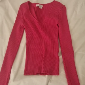 rosa sommar topp 2000s/stockholm/grisch - Säljer en ribbad långärmad tröja från Amisu i en snygg rosa färg. Tröjan har v-ringning och är figurnära med stretchigt material. Perfekt för dig som gillar en enkel men stilren look. Passar till både jeans och kjol.
