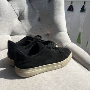 Svarta mockasneakers med vit sula - Stilrena svarta sneakers i mocka med klassisk vit platt sula. Skorna har rund tå och svarta snören för en enkel och clean look. Perfekta för dig som gillar minimalistisk stil och vill ha ett par sneakers som funkar till det mesta. Köpte dem nya för 999