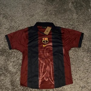 Barça x Nike Cactus Jack fotbollströja L - Exklusiv FC Barcelona x Nike x Cactus Jack fotbollströja i röd och marinblå med breda vertikala ränder. Broderat klubbmärke och Nike-logga framtill, tryck med 'Cactus Jack', nummer 2 och 'BARÇA' på ryggen.