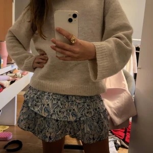 Blåvit volangkjol med mönster - Supersöt kort kjol med blått och vitt mönster, volanger och smock i midjan. Storlek 146-152 men passar fortfarande mig som har 158-164 ( storlek S) inga tecken på användning knappt använd