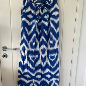 Blåvit långkjol från H&M i linneblandning - Säljer en blåvit långkjol från H&M i skön linneblandning💙Kjolen har ett coolt mönster, resår i midjan och knytband för extra passform🤍Fint skick💙