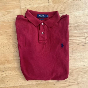 Ralph Lauren piké - Röd långärmad pikétröja från Polo Ralph Lauren i bomull. Custom fit-modell som ger en snygg passform. Perfekt för dig som gillar stilren klädsel. Står L i storlek men skulle säga den passar både M och L.