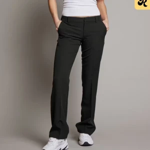 Svarta lågmidjade kostymbyxor från BikBok - Säljer ett par svarta kostymbyxor från BikBok med smått utsvängda ben ner till och kant nere vid foten på byxbenet. Byxorna är lågmidjade/medelhög midja. Byxorna är endast använda ca 5 gånger, och är i storlek 38. Skriv gärna för frågor och prisförslag! 🥰nypris: 500 kr.