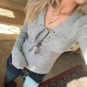 tröja med snörning - Säljer en grå ribbad tröja med v-ringning och snygg snörningsdetalj framtill. Skriv för fler bilder eller frågor💞💞