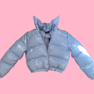 Ljuslila pufferjacka från PrettyLittleThing - Säljer en glansig ljuslila pufferjacka från PrettyLittleThing. Jackan har hög krage, dragkedja framtill och elastisk nederkant. Perfekt för att hålla lite värme och sticka ut med en trendig look :)✨. Aldrig använd, nypris ligger på ca 500kr men säljer för 250kr! :)🩷
