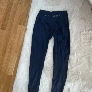 Mörkblå leggings från Relode - Säljer ett par mörkblå leggings från Relode med hög midja och tight passform. Perfekta för träning eller chill. Mjukt och stretchigt material som sitter skönt på kroppen. Diskret logga framtill i midjan. Är lite nopprig på vissa ställen 😊passar S.