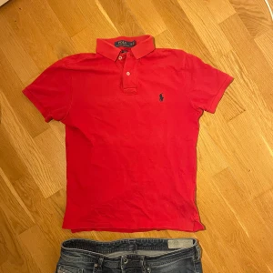 Röd pikétröja från Polo Ralph Lauren - Röd pikétröja från Polo Ralph Lauren i modellen Custom Slim Fit. 