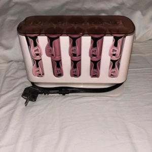 Remington värmespolar med klämmor - Säljer ett set med rosa och svarta värmespolar från Remington. Setet innehåller flera spolar i olika storlekar samt matchande klämmor, allt i en smidig förvaringsbox med lock och sladd. Perfekt för att skapa volym och lockar i håret. Dem är endast provade och i nyskick. Nypris 600 säljer för 400