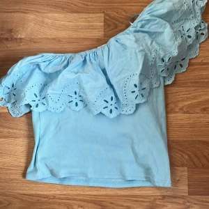 Ljusblå offshoulder topp med volang från Zara - Säljer denna trendiga ljusblå offshoulder topp från Zara, inte använd många gånger, säljer då den inte passar mig längre. Den är i storlek 164 men passar även xs