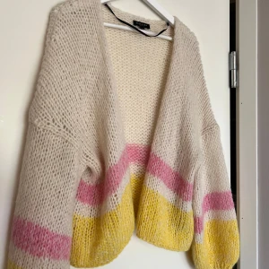 Stickad kofta  - Intressekoll på min supermjuk och oversized stickad kofta från selected i vit beige med rosa och gult. Koftan har långa ärmar och en öppen front utan knappar. Perfekt för både sommar och vinter en färgglad touch till outfiten.💗