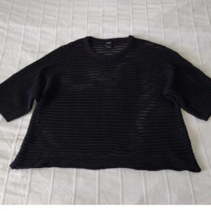 Svart stickad see through tröja från Lindex med korta ärmar  - Säljer en svart stickad tröja från Lindex med vid passform och trekvartsärm. Tröjan är luftig och har ett transparent, randigt stickmönster. Skitsnygg och i fint skick. Storlek S.