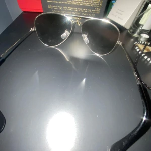 Svarta pilotglasögon från Ray-Ban - Klassiska pilotglasögon från Ray-Ban med svarta glas och silvriga metallbågar. Snygg och tidlös design som passar till många stilar. Ray-Ban-loggan syns tydligt på linsen. Priset kan diskuteras vid snabb affär 