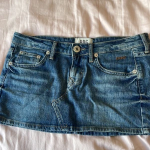 Jeanskjol från BDG Urban Outfitters - Säljer en blå jeanskjol från Urban Outfitters. Perfekt för dig som gillar en denimlook. BDG-logga på fickan där bak. Köpt för 400kr💕