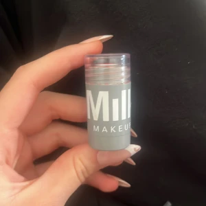 Milk Makeup mini stick rouge - Säljer en mini rouge stick från Milk Makeup i en fräsch korallrosa nyans. Perfekt att ta med i väskan för snabba touch-ups. Enkel att applicera direkt på kinderna för en naturlig glow.