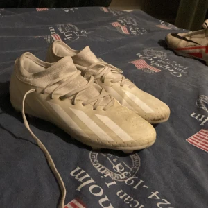 Vita Adidas Crazyfast fotbollsskor - Säljer ett par vita Adidas Crazyfast fotbollsskor med klassiska tre ränder på sidan. Skorna har snörning och är tillverkade i syntetmaterial. Perfekta för dig som vill ha lätta och snabba skor på planen. Ganska smutsiga men det går bort . Lite slitna.