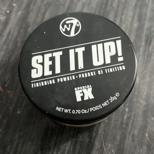 W7 Set It Up! Finishing Powder - Transparant finishing powder från W7 i burk med svart lock. Perfekt för att fixera sminket och ge en matt finish. Lättviktig, vit puderformula som passar de flesta hudtoner. Innehåller 20g.