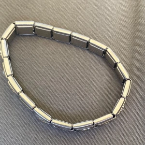 Silverfärgat armband med länkar - Säljer ett stilrent armband i silverfärg med rektangulära länkar. Armbandet har en elastisk design som gör det enkelt att ta på och av. Passar perfekt för dig som gillar minimalistiska accessoarer.