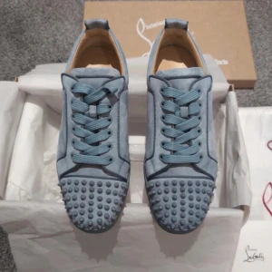 Ljusblå Christian Louboutin - Säljer ett par ljusblå sneakers från Christian Louboutin med nitar. Skorna är helt nya ej använda , vid frågor dm:a