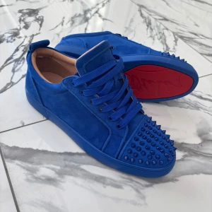 Christian Louboutin Sneakers Blå - Sneakers från Christian Louboutin i den eftertraktade blå färgen. Röd sula som signaturdetalj. Perfekta för dig som vill sticka ut med stil.