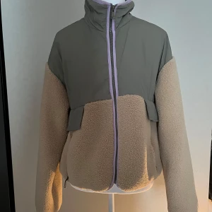 Beige teddyjacka  - Säljer en snygg teddyjacka i beige med grått parti upptill och dragkedja framtill. Jackan är från Zara