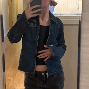 Mörkblå jeansjacka från Weekday - Säljer en mörkblå jeansjacka från Weekday med dragkedja framtill och klassisk krage. Jackan har långa ärmar och en rak, något croppad passform.