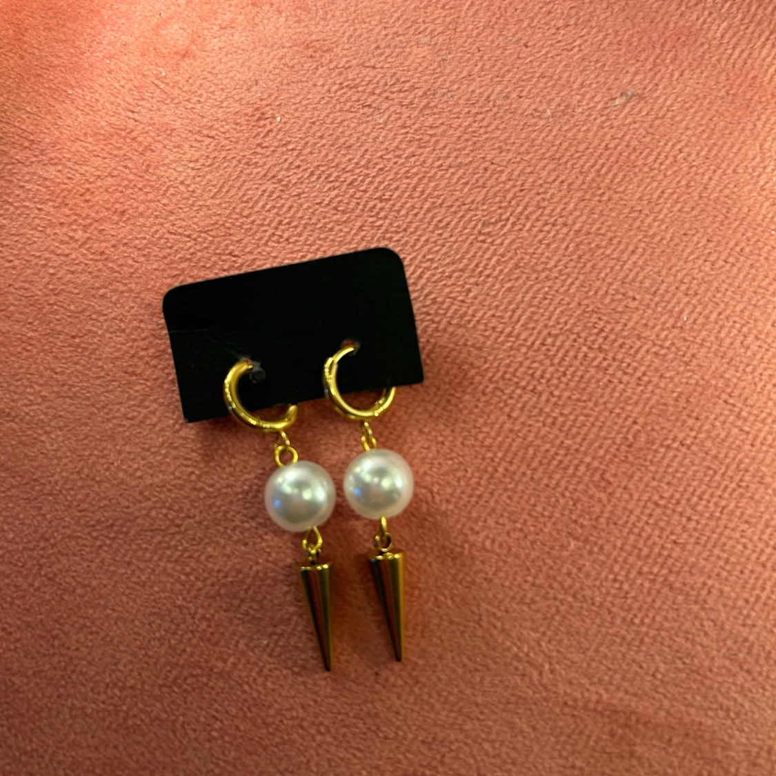 Guldiga örhängen med pärlor och konformad detalj