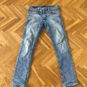 Nudie jeans herr  - Säljer ett par klassiska ljusblå nudie jeans. Perfekta för en avslappnad stil och funkar året runt. Dragkedja och knapp i gylfen. Finns ett litet hål (bild 3) men annars bra skick.