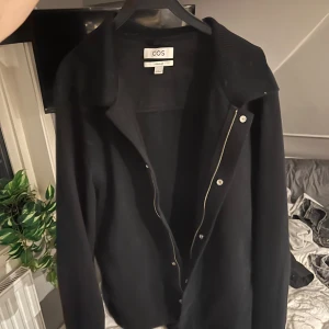 Svart stickad overshirt från COS - Säljer en svart stickad overshirt/jacka från COS med dragkedja och stora slag. Den är knappt använd, köpt i butik och i nyskick! Hör av er vid mer frågor! 
