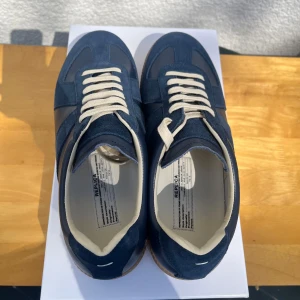 Maison Margiela - Säljer ett par stilrena mörkblå sneakers från maison margiela. Hör av er om ni har några frågor!