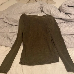 Olivgrön stickad tröja från Vila - Säljer en olivgrön stickad tröja från Vila. Tröjan har lång ärm, rund halsringning och ribbade muddar vid ärmslut och nederkant. Perfekt för lager-på-lager under kyliga dagar.