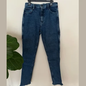 Levi's Line 8 blå jeans med rå kant - Säljer ett par mörk blå Levi's Line 8 jeans med hög midja och formföljande ben. Jeansen har råa, fransiga benslut och slim fit passform. 