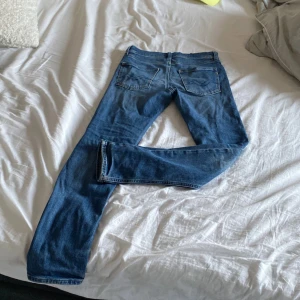 Blå jeansbyxor från Replay - Säljer ett par klassiska blå jeansbyxor från Replay med raka ben och snygga detaljer på bakfickorna. Byxorna har slim passform och är perfekta för dig som gillar en tidlös jeansstil. Märket Replay syns tydligt på insidan. Storleken är 12 år men går att använda ända tills 160 nypris ca 800