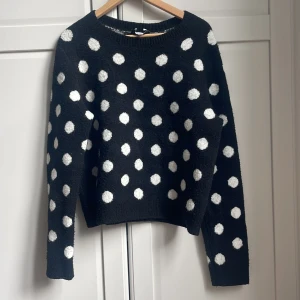 Svart prickig stickad tröja från & Other Stories - Säljer en svart stickad tröja från & Other Stories med vita prickar. Tröjan har rund halsringning och långa ärmar. Tröjan är lite nopprig. 